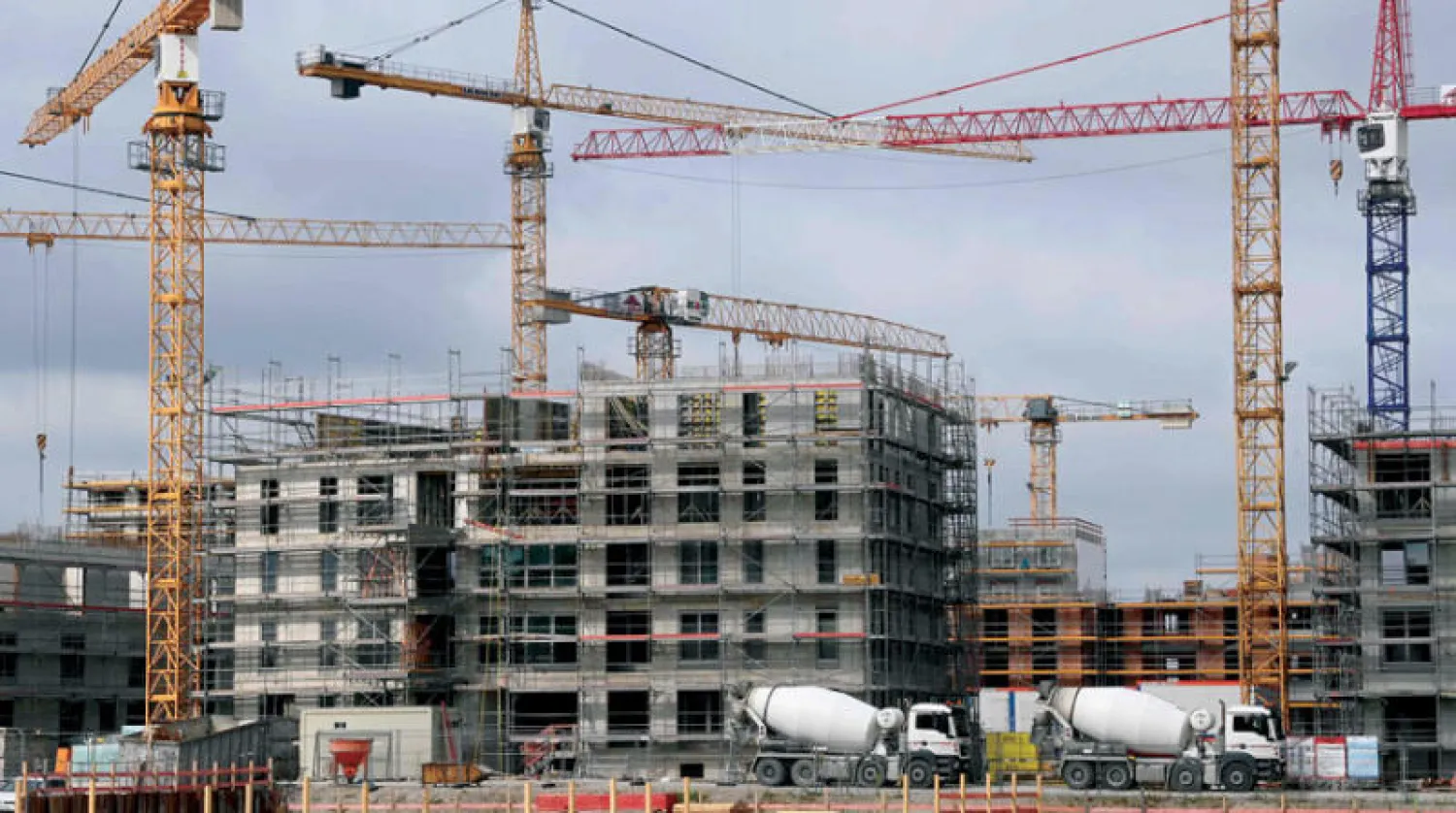 رافعات حول مبنى سكني قيد الإنشاء في موقع بناء بميونيخ جنوب ألمانيا في 13 يوليو 2021 (أ.ف.ب)