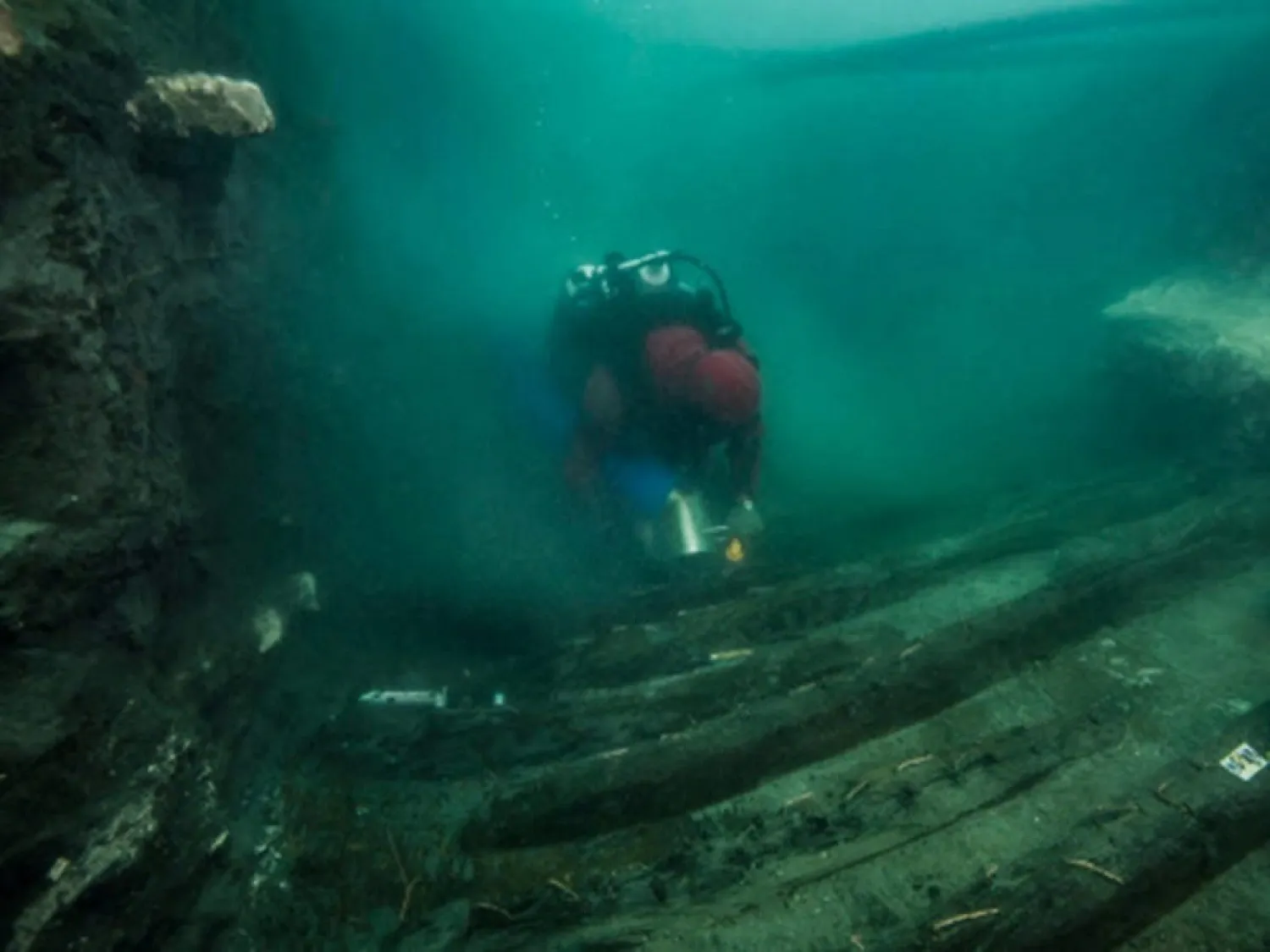 A handout picture released by the Egyptian Ministry of Tourism and Antiquities (MOA) on July 19, 2021 shows a diver exploring the hull of a military vessel discovered in the sunken city of Thônis-Heracleion in Abu Qir bay, on Egypt's northern Mediterranean coast. (Egyptian Ministry of Antiquities / AFP)