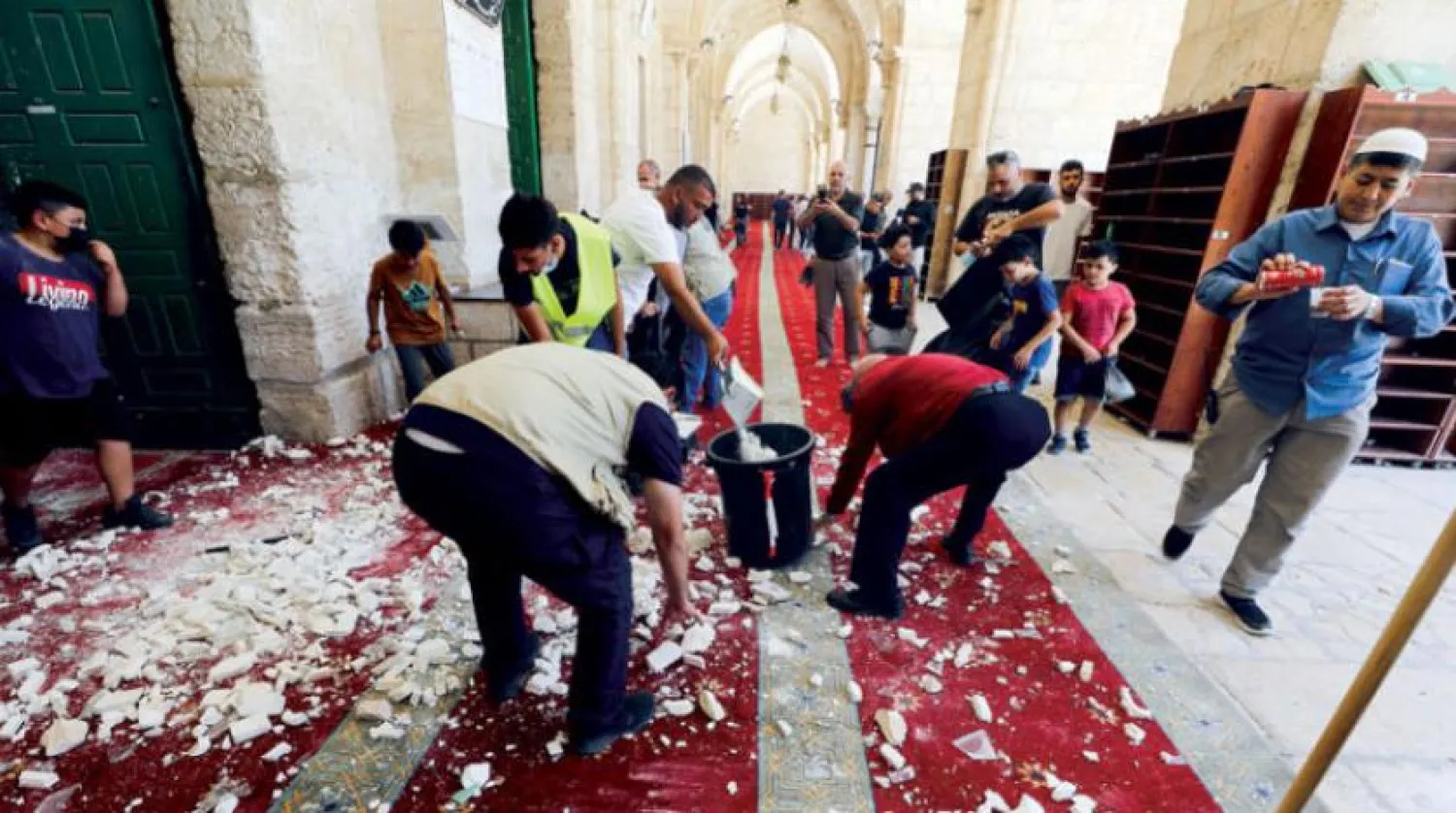 People clean the Al-Aqsa compound after limited clashes between Muslim worshippers and Israeli police on Sunday. (Reuters)