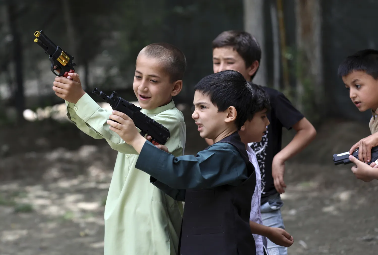 أطفال أفغان يلعبون بمسدسات بلاستيكية في كابل (أ.ب)