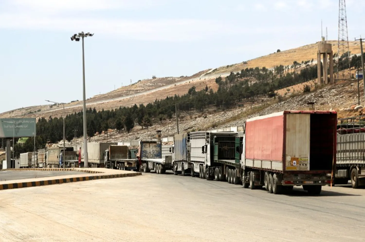 A road sign that reads "Welcome to Bab al-Hawa crossing" is seen at Bab al-Hawa crossing at the Syrian-Turkish border, in Idlib governorate, Syria June 10, 2021.REUTERS/Khalil Ashawi