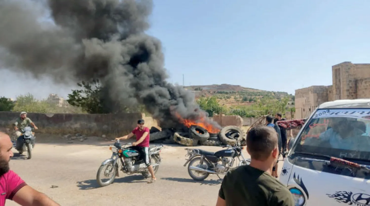 مدنيون قرب نقطة عسكرية تركية في البارة بجبل الزاوية شمال غربي سوريا أمس (الشرق الأوسط)