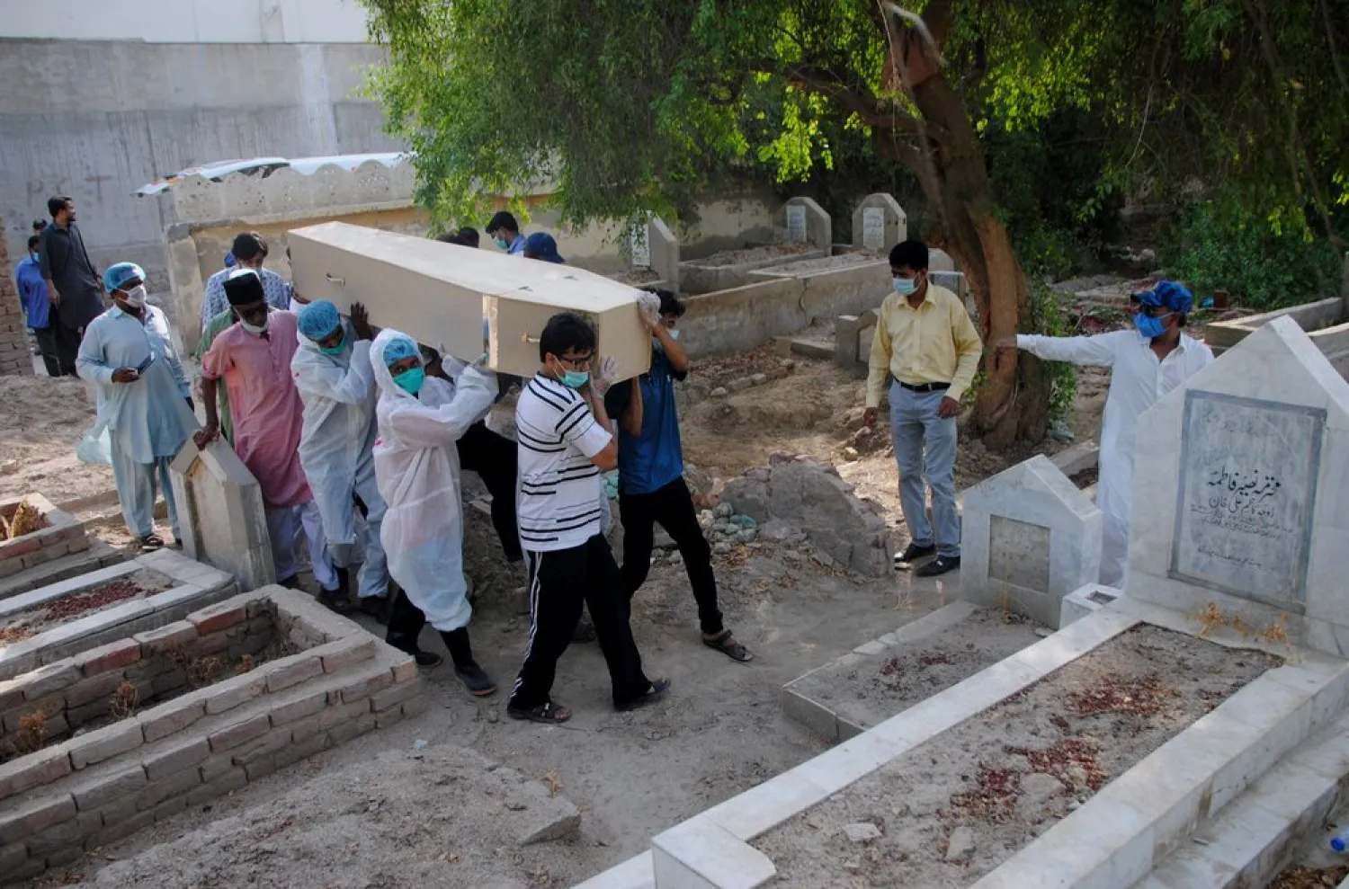 FILE - In this Jan. 6, 2020 file photo, rescue workers and family members carry the casket of Khursheed Bibi, who died due to coronavirus, for her burial at a cemetery in Hyderabad, Pakistan.  (AP Photo/Pervez Masih, File)
