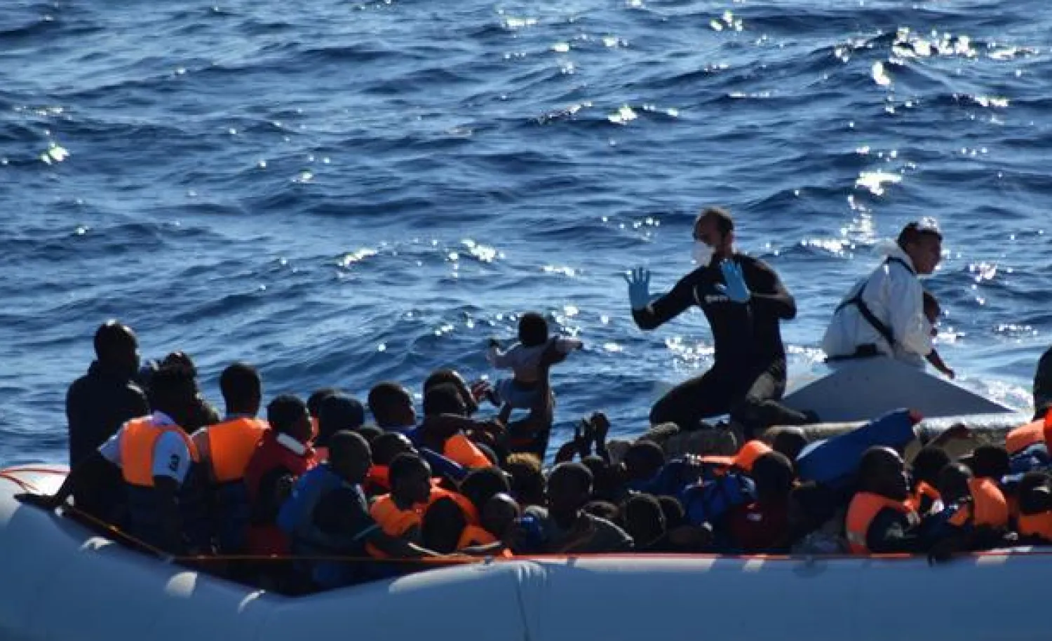 Migrants sit in their rubber dinghy during a rescue operation by Italian navy ship Borsini (unseen) off the coast of Sicily, Italy, in this handout picture courtesy of the Italian Marina Militare released July 19, 2016. Marina Militare/Handout via REUTERS
