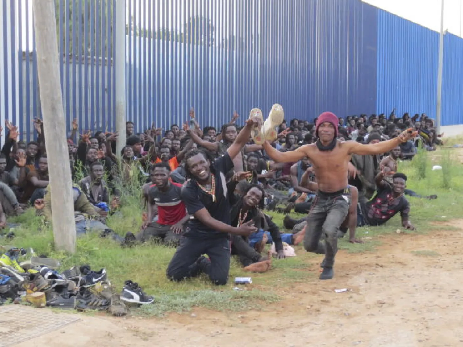  A group of Migrants celebrate at a migrant processing center in Melilla, Spain, Thursday July 22, 2021. (AP)

