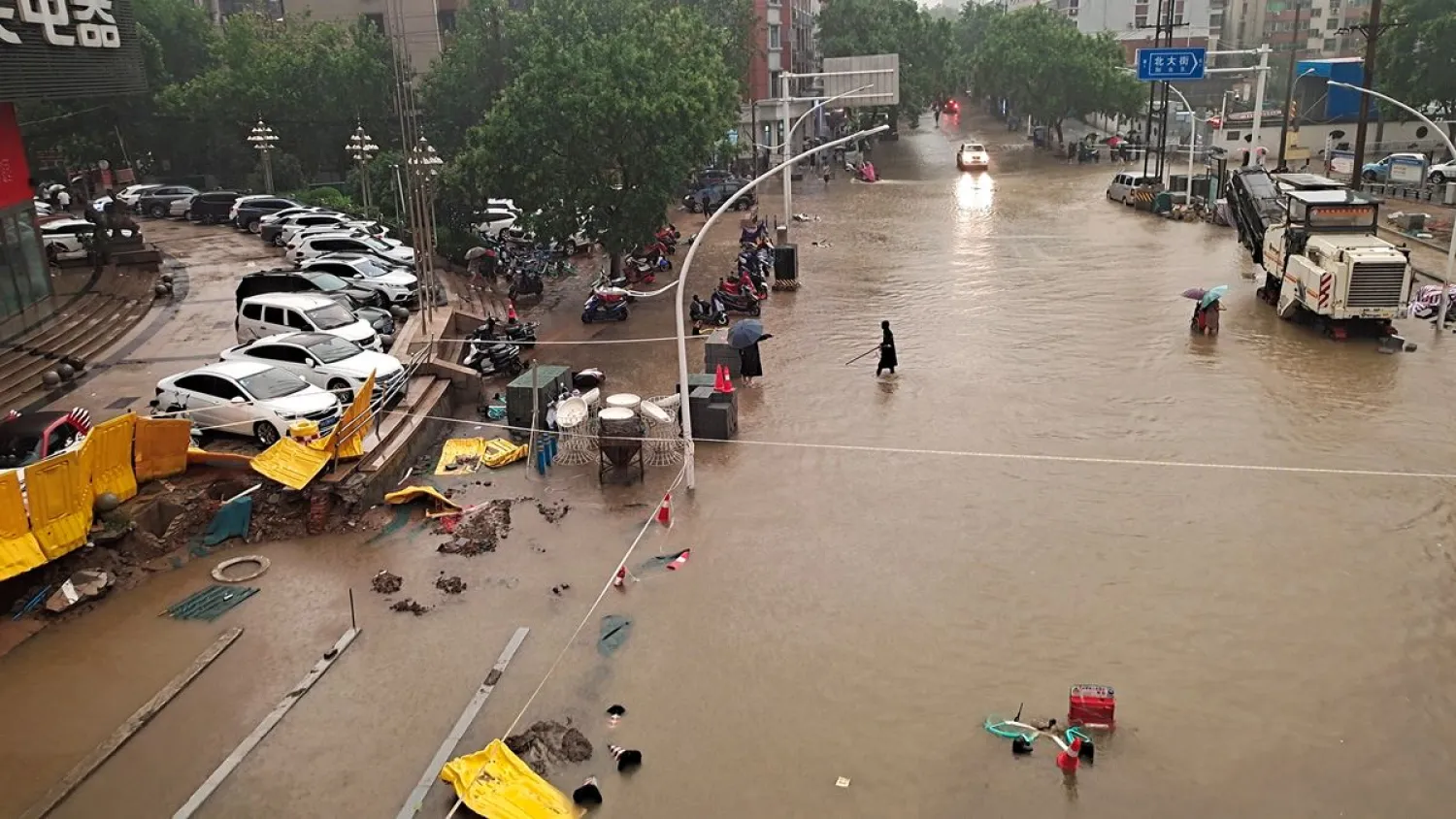 People wade through floodwaters on a road amid heavy rainfall in Zhengzhou, Henan province, China July 20, 2021. China Daily via REUTERS 