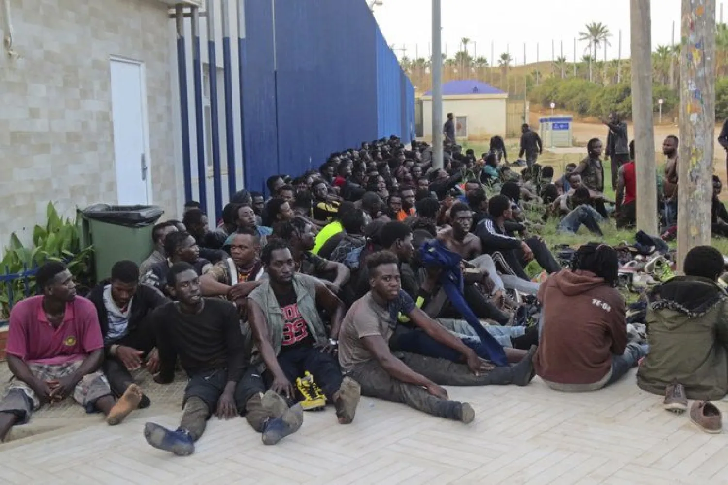 Migrants sit at a migrant processing center in Melilla, Spain on Thursday. Moroccan navy this week rescued 368 migrants including 3 children trying to cross to Spain. (AP)
