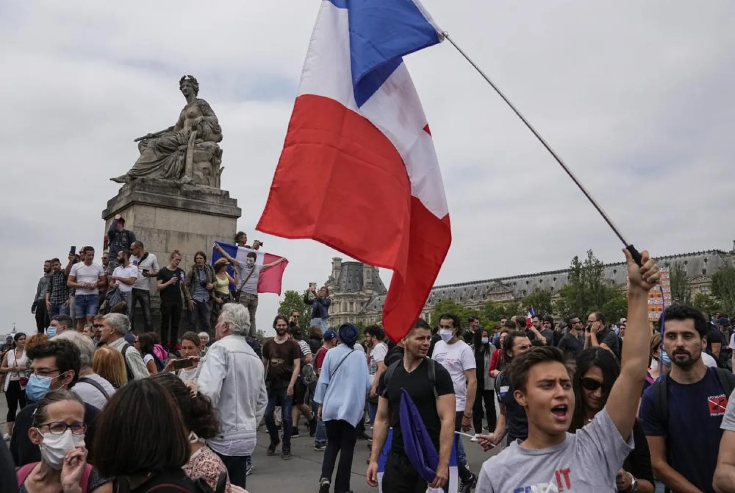 Anti-vaccine protester march with the French national flag during a rally in Paris, Saturday, July 17, 2021. (AP)
