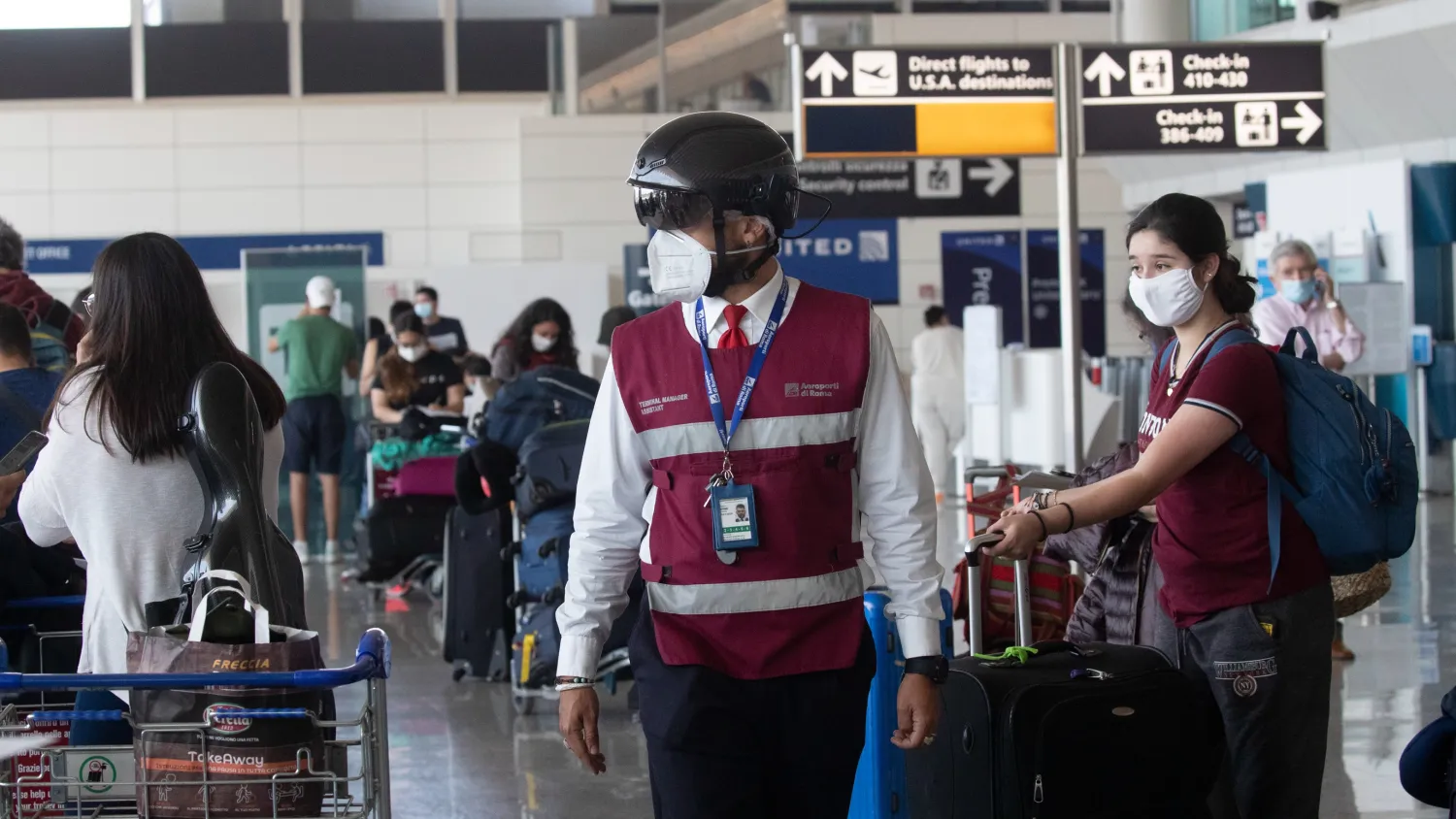 A member of airport security staff wears a smart helmet scanner, which measures the body temperature of passengers for possible coronavirus symptoms, at Leonardo da Vinci–Fiumicino Airport in Rome, Italy, June 3, 2020. /AP

