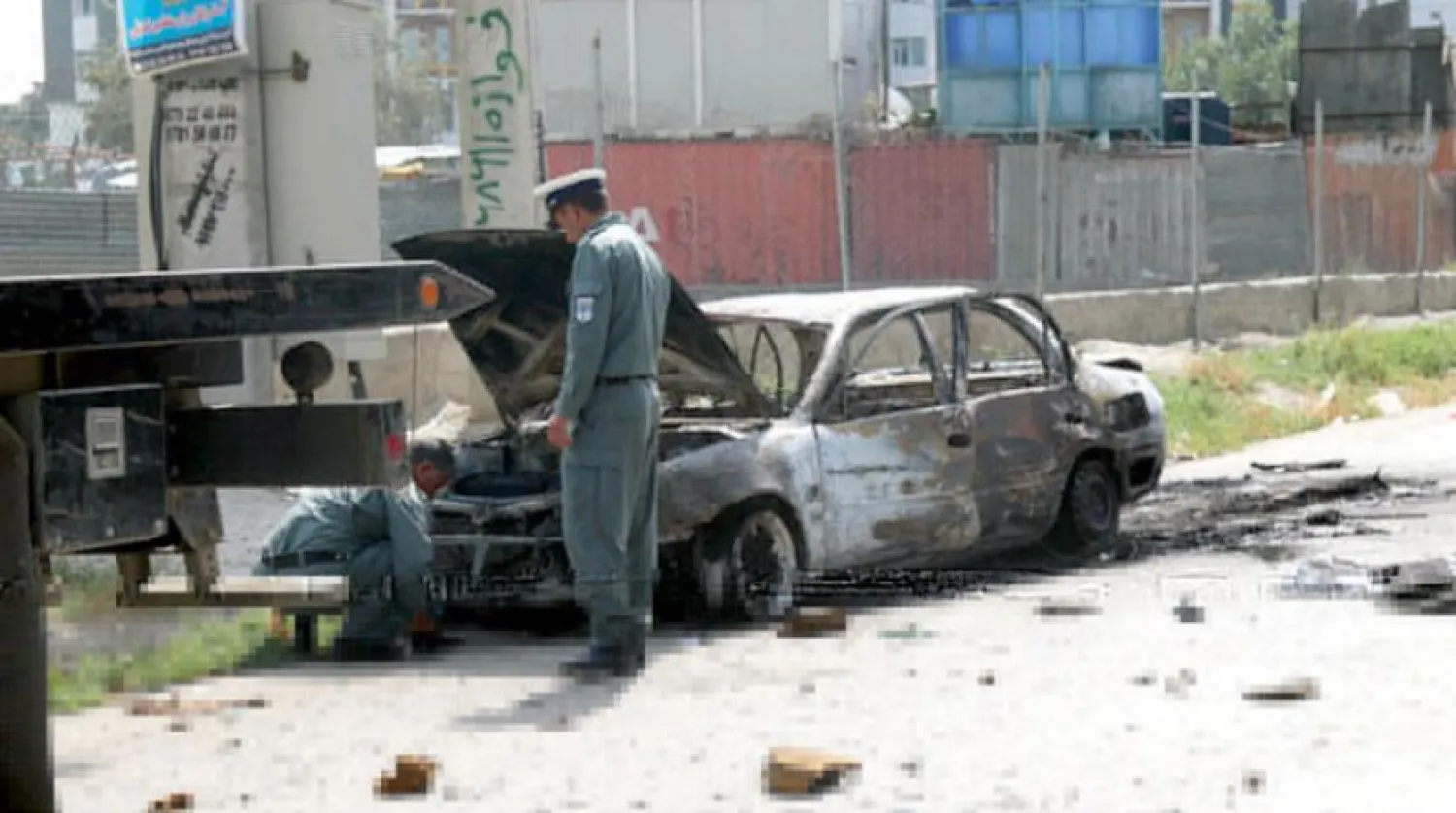 Polis Kurban Bayramı namazı esnasında başkent Kabil’deki cumhurbaşkanlığı sarayı yakınlarına isabet eden füze sonucu hasar gören bir arabayı inceliyor. (AFP)