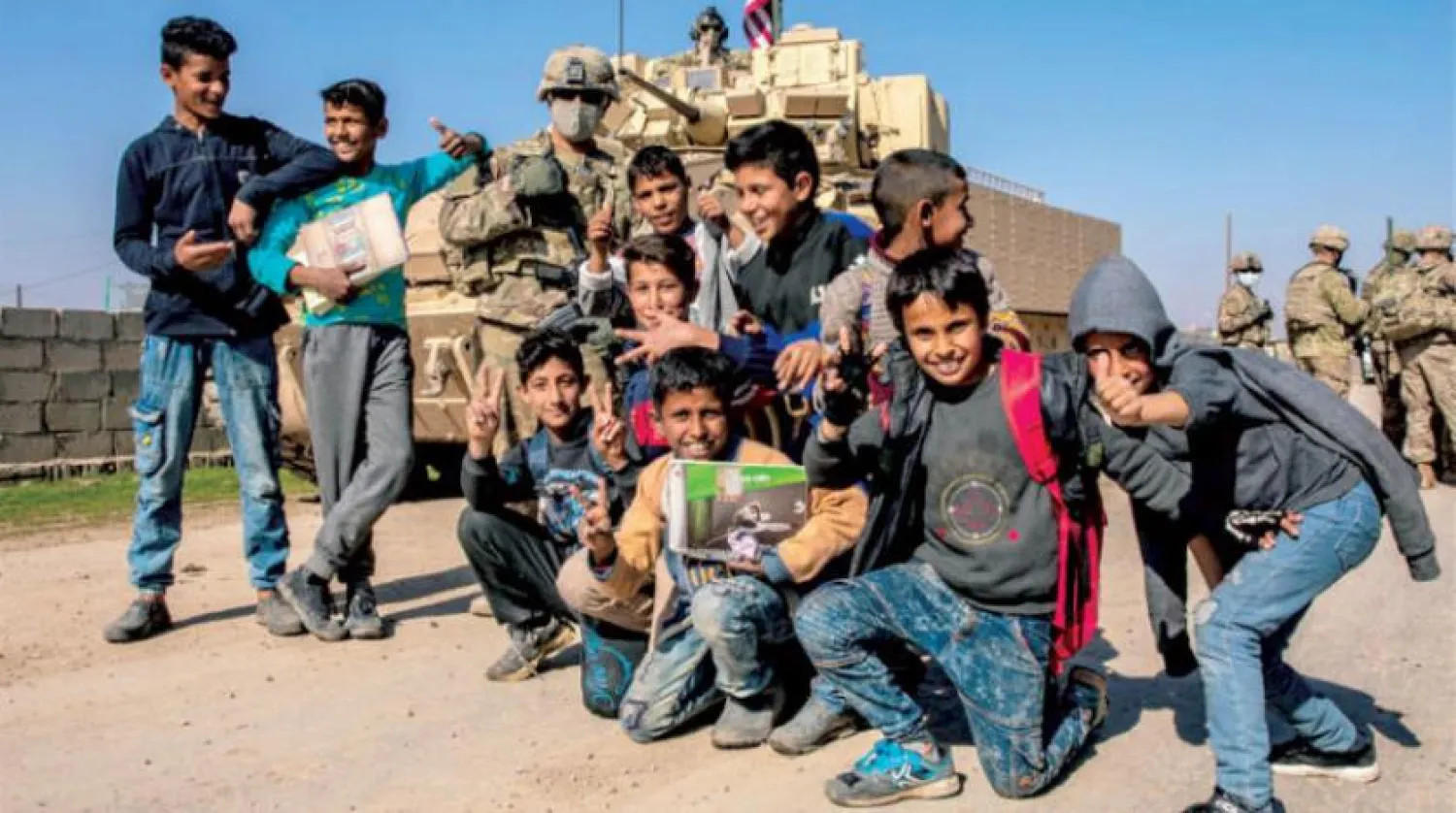 Geçtiğiniz Mart ayında Kamışlı kırsalında çocuklarla hatıra fotoğrafı çektiren ABD askerleri (Şarku’l Avsat