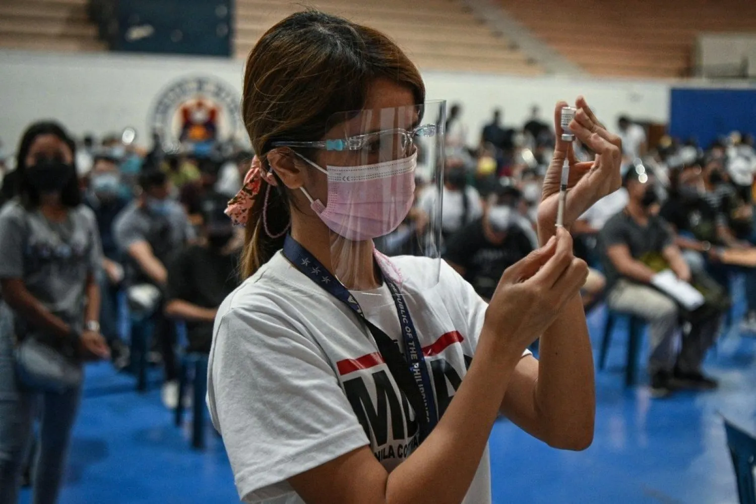 A health worker prepares a dose of the Pfizer Covid-19 jab at a vaccination center in Manila, Philippines. Photo: AFP
