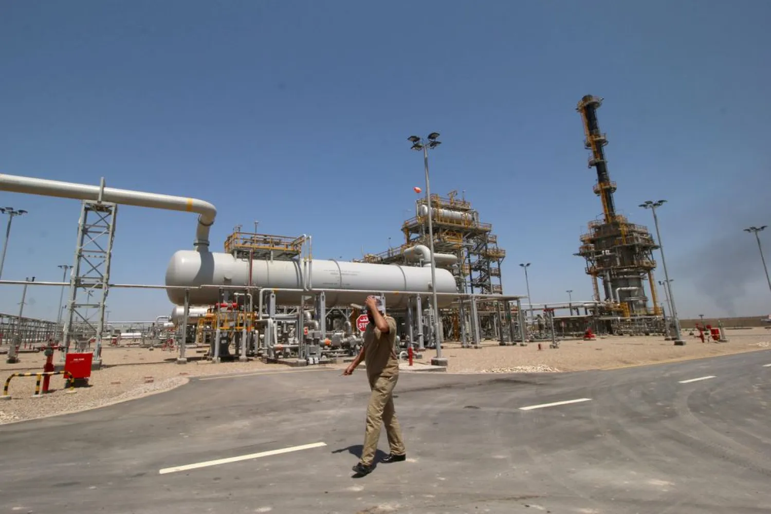An Iraqi staff of the West Qurna-1 oilfield, which is operated by ExxonMobil, walks past the West Qurna-1 oilfield, Iraq June 17, 2019. (Reuters)