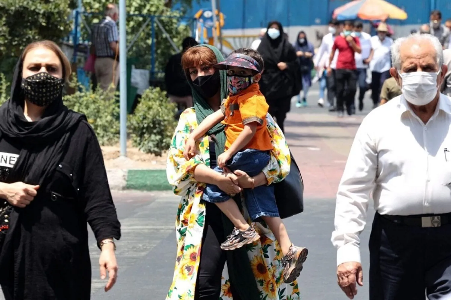 Iranians wear face masks to protect themselves from the coronavirus as they walk along a street in the capital Tehran, on July 3, 2021. (Getty Images)