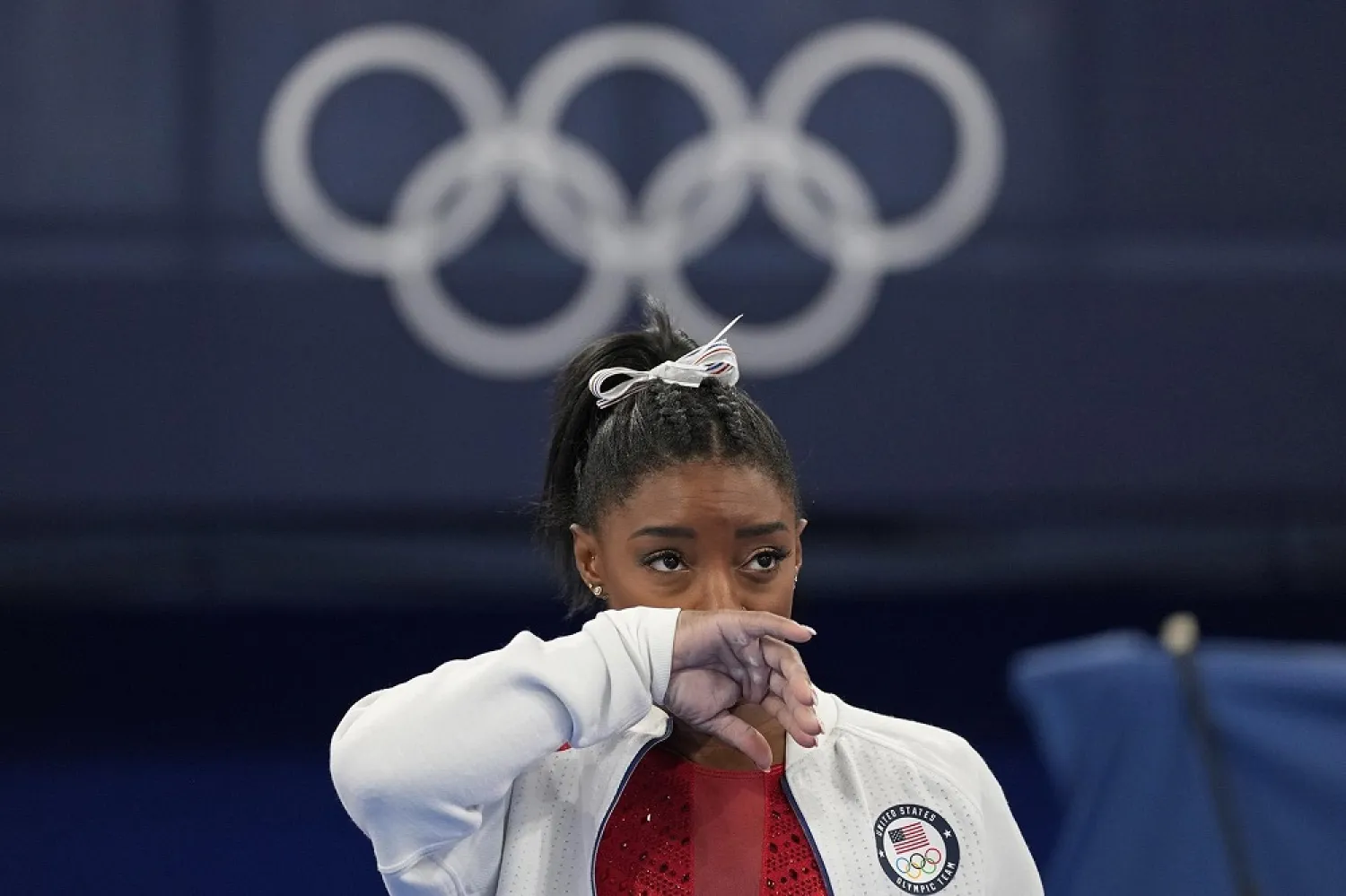 Simone Biles, of the United States, watches gymnasts perform after an apparent injury, at the 2020 Summer Olympics, Tuesday, July 27, 2021, in Tokyo. (AP)