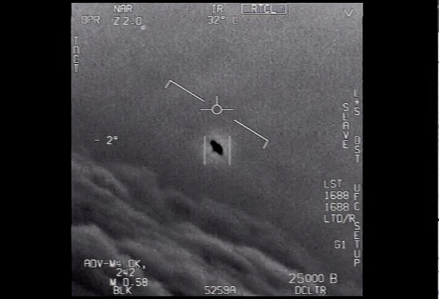 The image from video provided by the Department of Defense labelled Gimbal, from 2015, an unexplained object is seen at center as it soars high along the clouds, traveling against the wind. (Department of Defense via AP)
