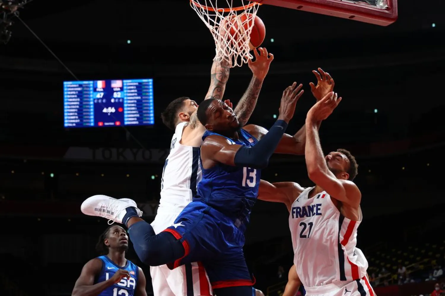 Tokyo 2020 Olympics - Basketball - Men - Group A - France v United States - Saitama Super Arena, Saitama, Japan - July 25, 2021. Edrice Adebayo of the United States in action at the rim with Rudy Gobert of France and Vincent Poirier of France REUTERS/Brian Snyder