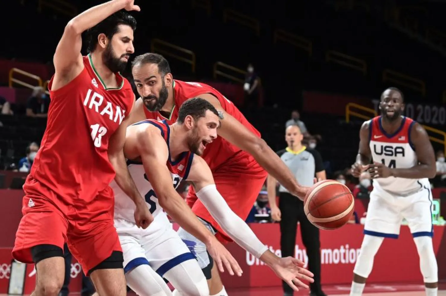 لاعب المنتخب الأميركي زكاري لافين (وسط) يحاول السيطرة على الكرة وسط لاعبي المنتخب الإيراني في منافسات كرة السلة بأولمبياد طوكيو (أ.ف.ب)