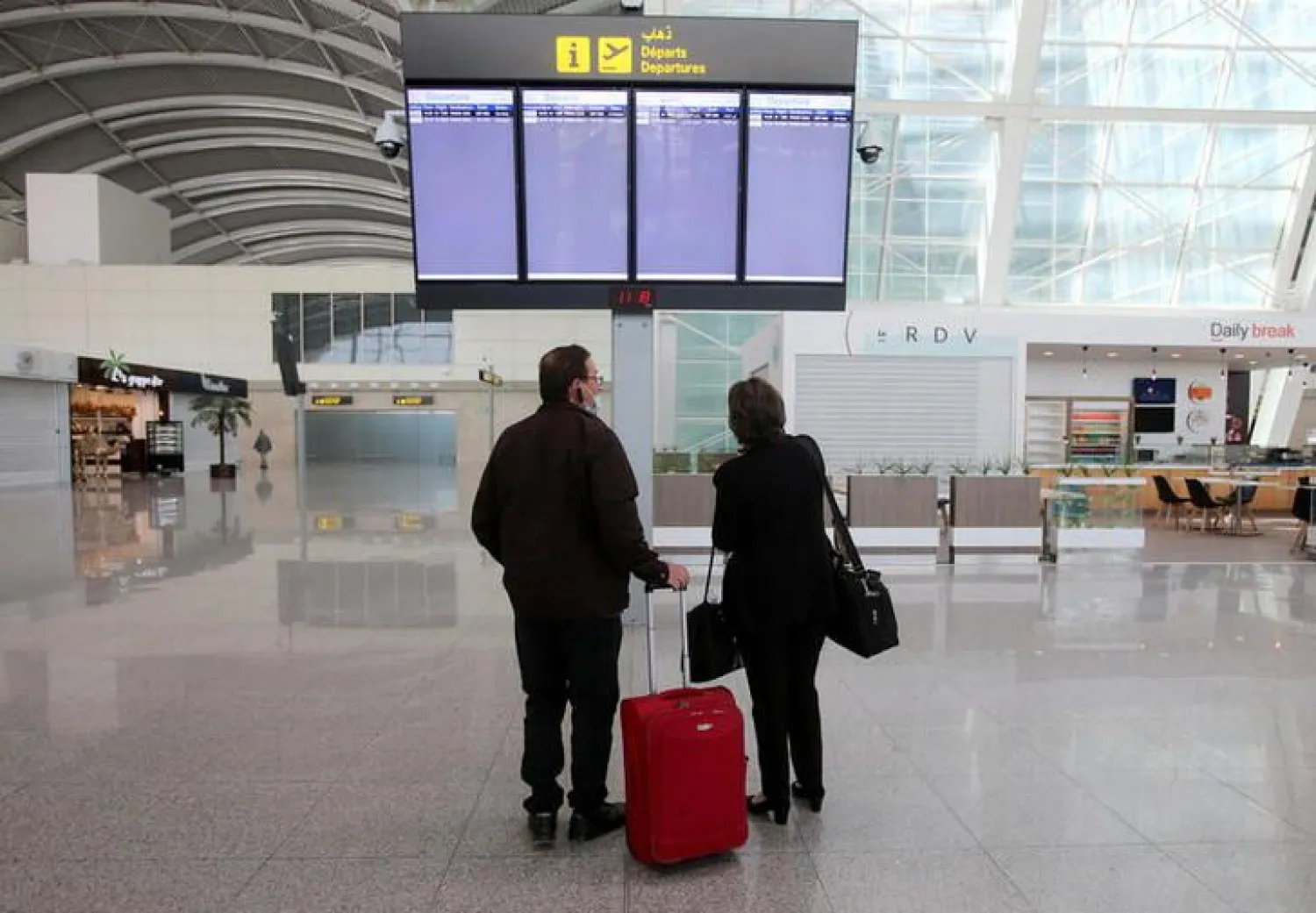 Passengers look at a departures board at Algiers Airport in Algiers, Algeria, June 1, 2021. REUTERS/Ramzi Boudina
