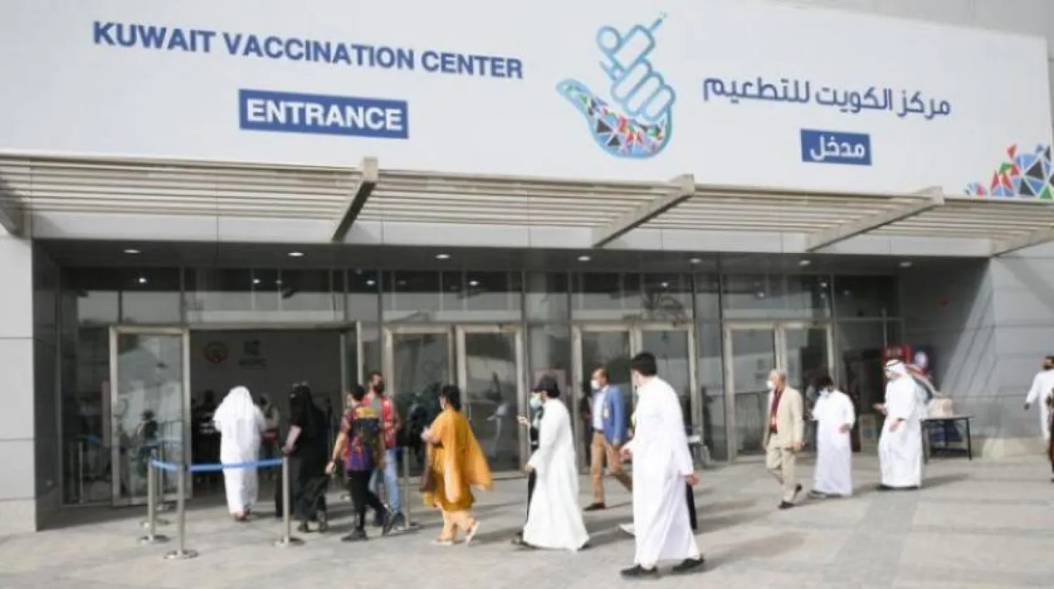 People wait outside a vaccination center in Kuwait. EPA