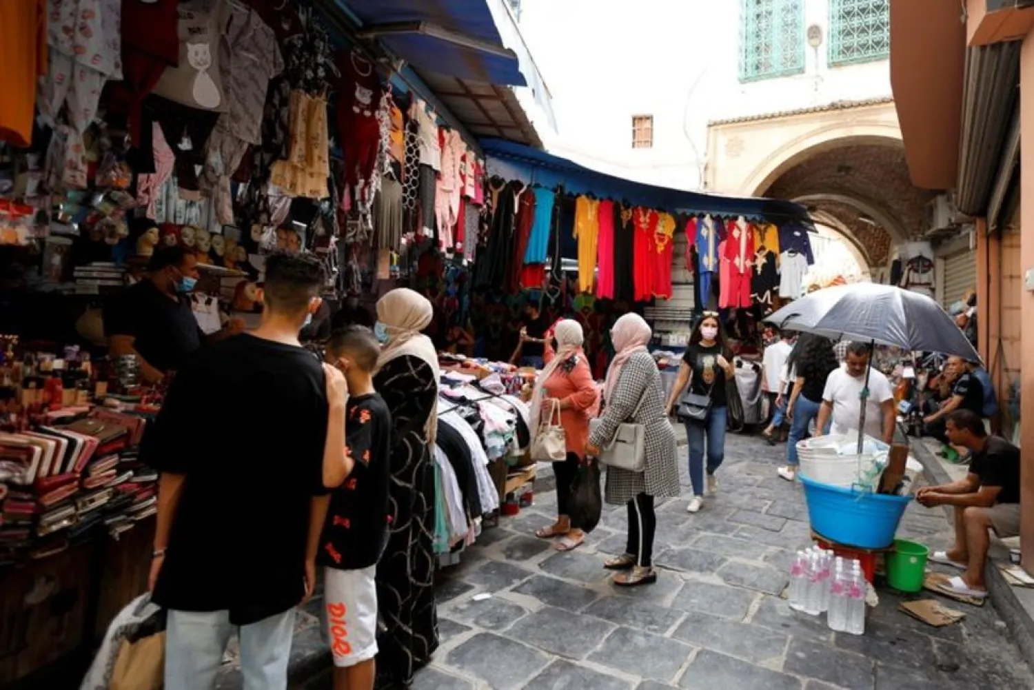 People walk past shops in the Medina, in the Old City of Tunis, Tunisia, July 27, 2021. (Reuters)