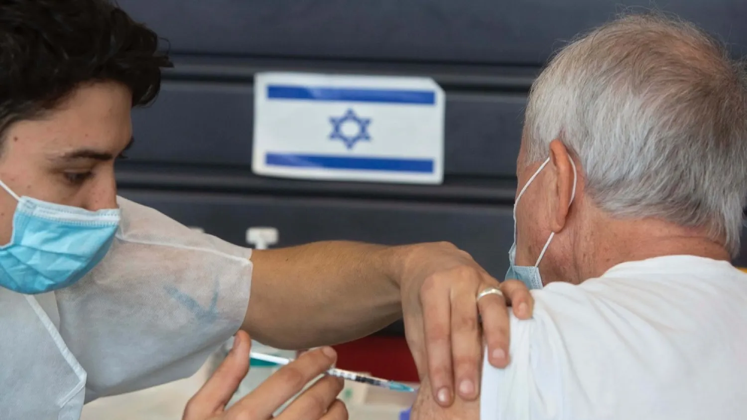 An Israeli receives a coronavirus vaccine from medical staff at a COVID-19 vaccination center in Tel Aviv, Israel, Jan. 6, 2021. (AP)