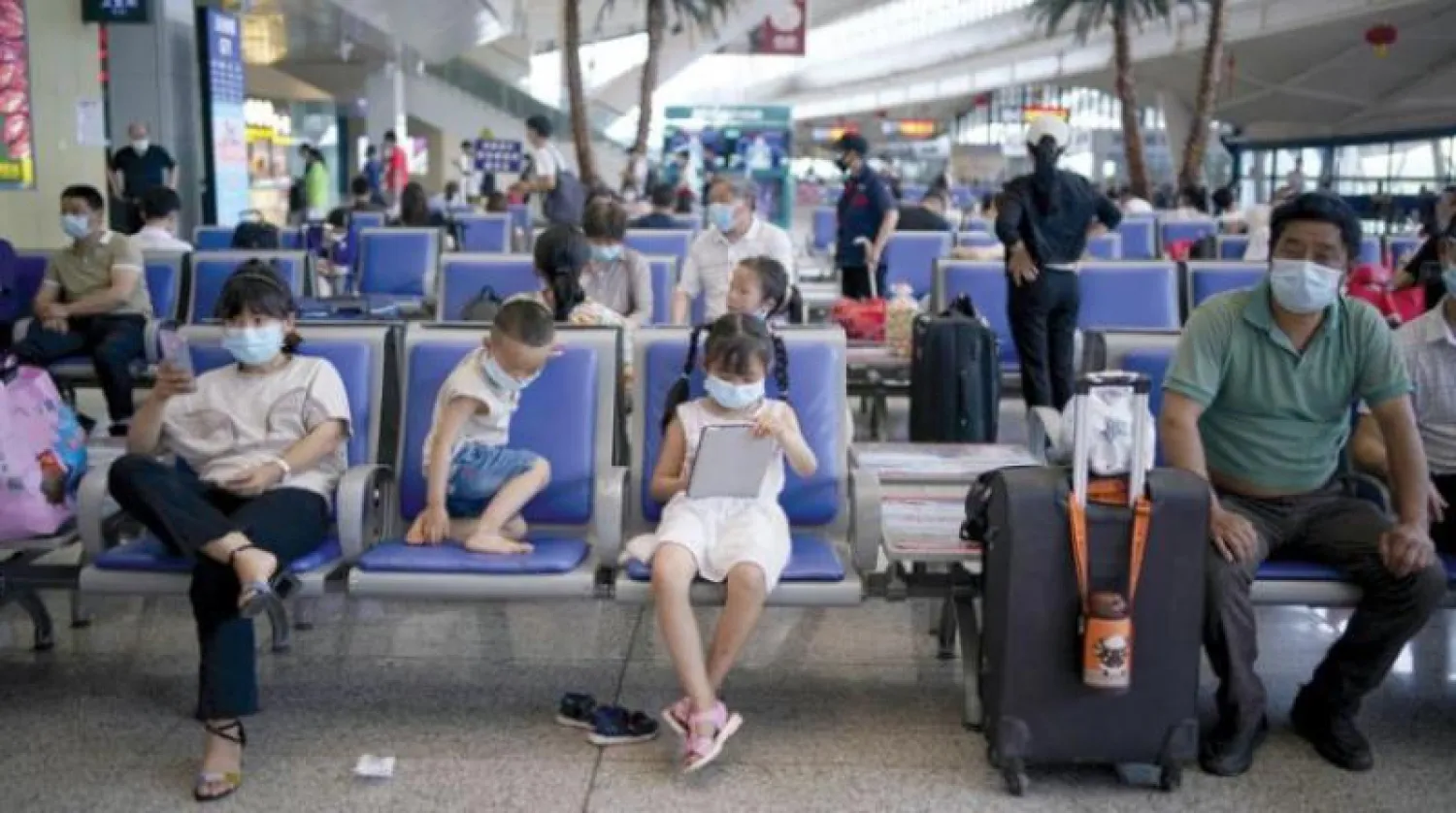 ركاب في محطة قطارات في ووهان الصينية التي ظهر فيها الفيروس للمرة الأولى (رويترز)