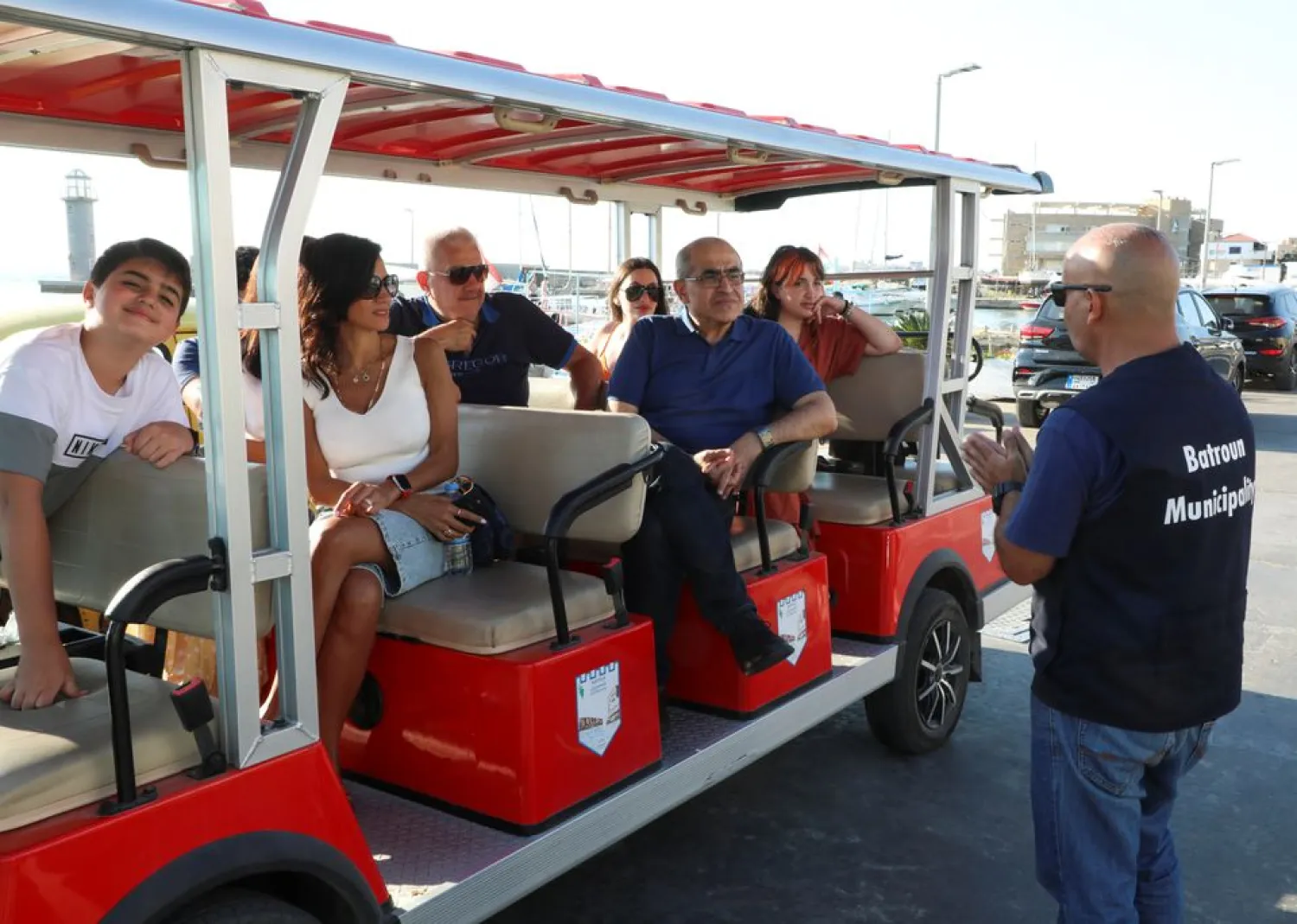 A tourist guide talks to visitors as they sit on an electric vehicle in Batroun, Lebanon June 5, 2021. REUTERS/Mohamed Azakir