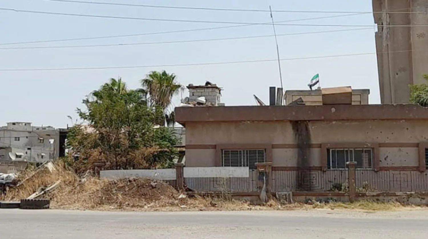 رفع علم المعارضة السورية فوق مبنى بلدية تسيل غرب درعا كان مركزاً للمخابرات الجوية السورية (تجمع أحرار حوران)