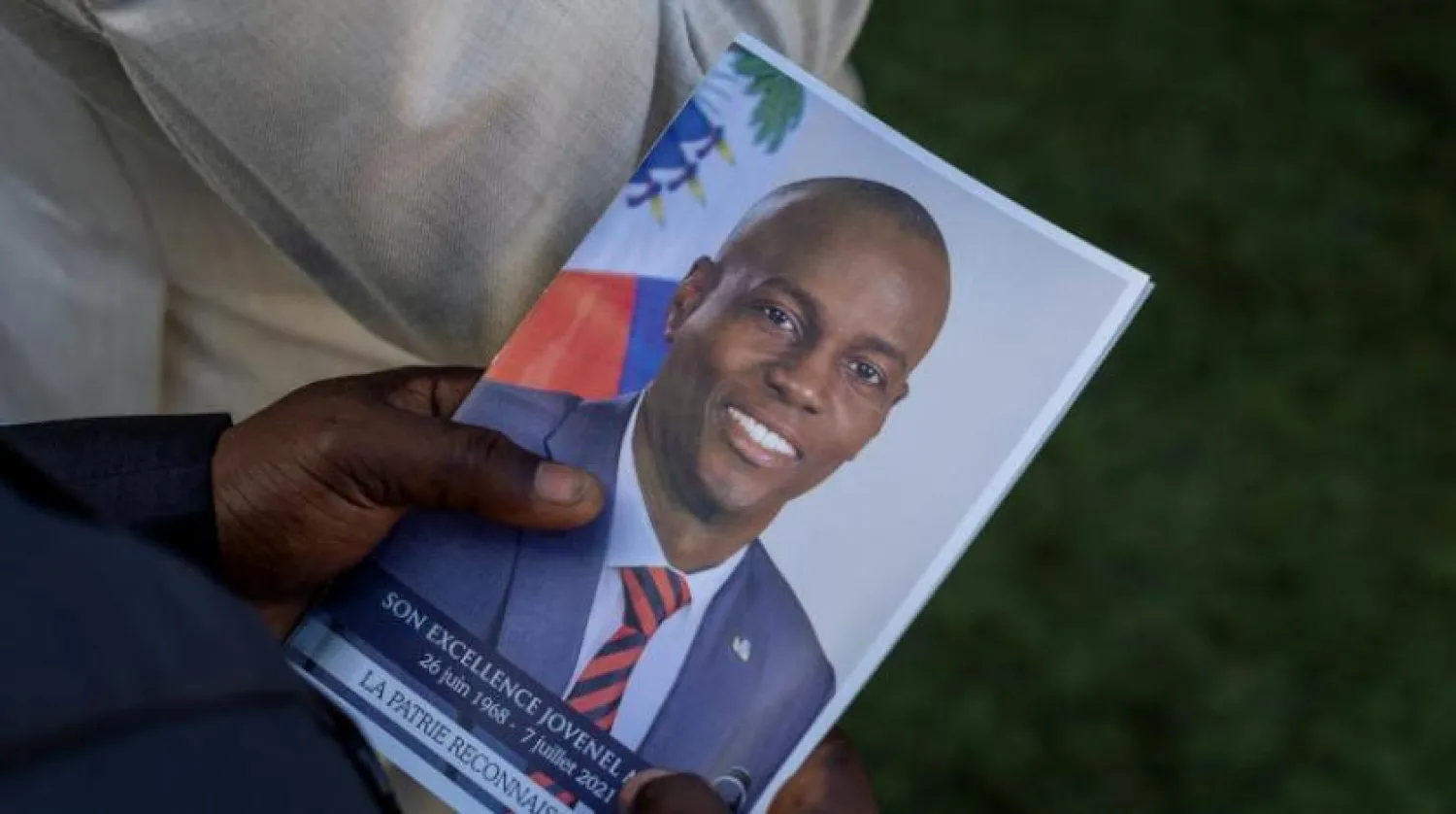A person holds a photo of late Haitian President Jovenel Moise, who was shot dead earlier this month, during his funeral at his family home in Cap-Haitien, Haiti, July 23, 2021. REUTERS/Ricardo Arduengo

