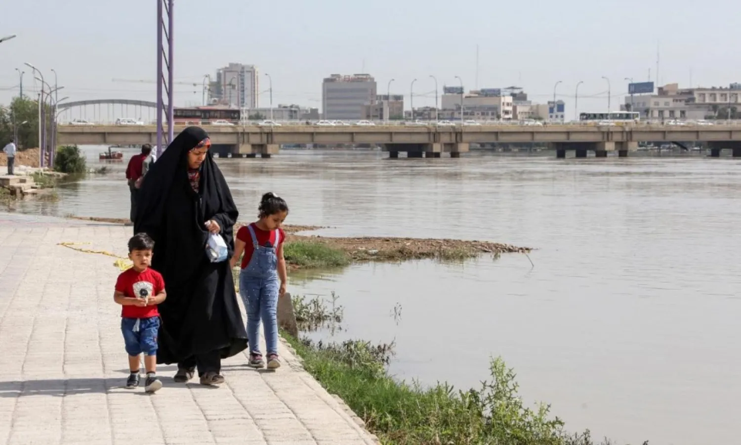 A woman walks with her children along the Karun River in Ahwaz, Khuzestan (File photo: AFP)