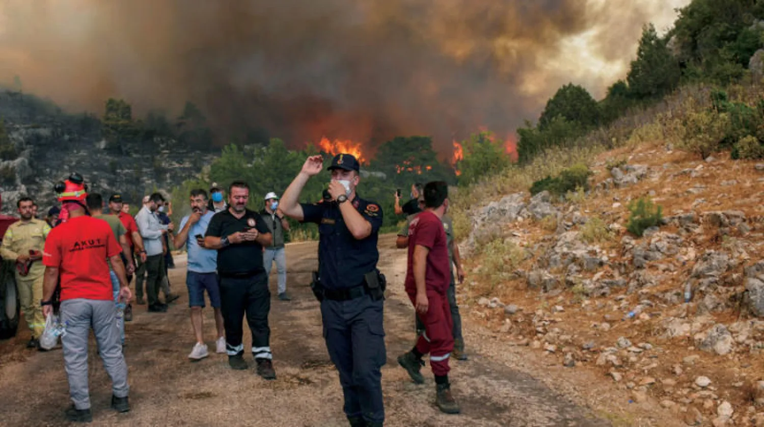 سكان يغادرون قريتهم في أنطاليا مع اقتراب ألسنة النار أمس  (أ.ب)