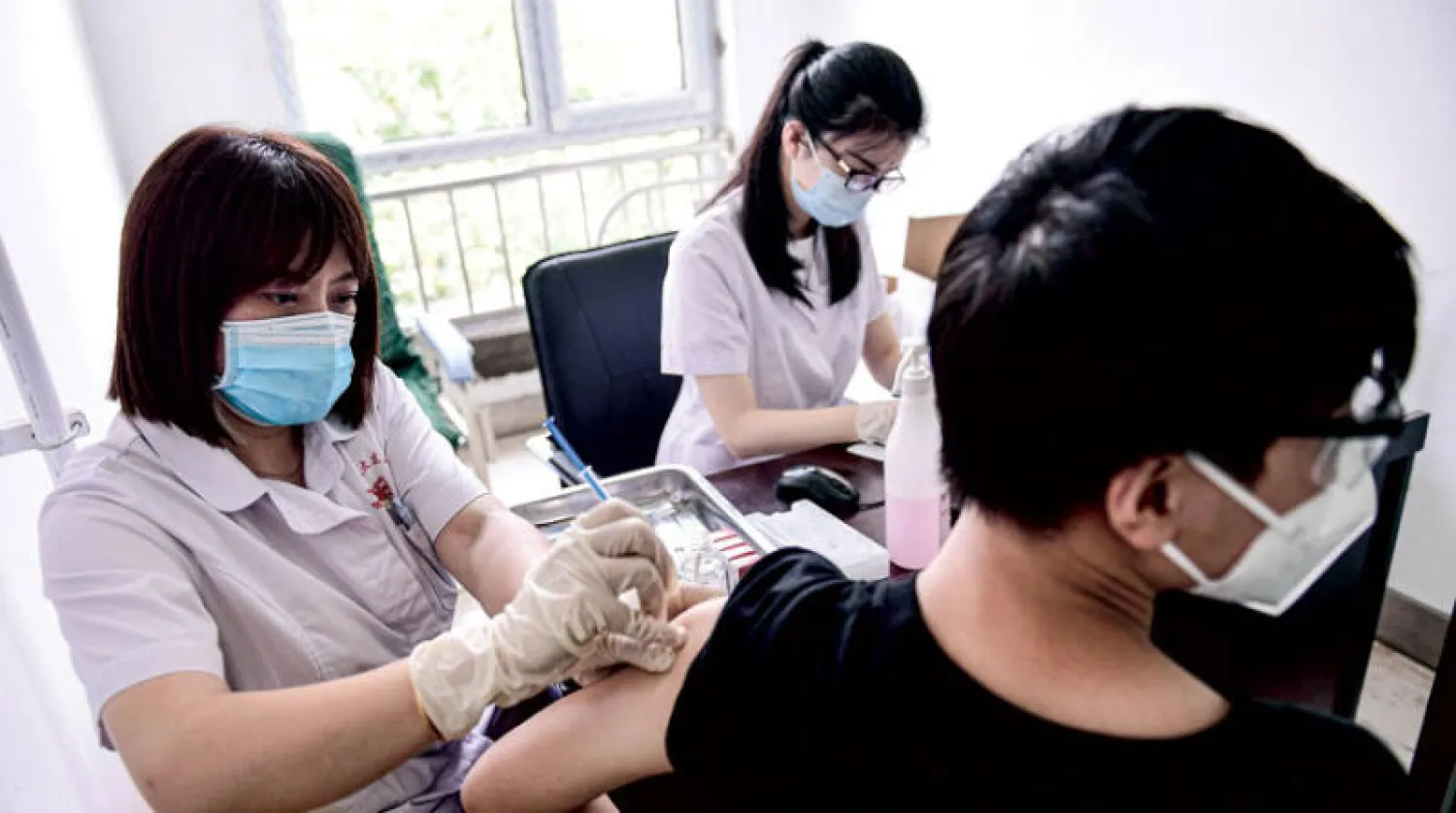 طالب يتلقى لقاح «سينوفاك» في الصين أمس (أ.ف.ب)