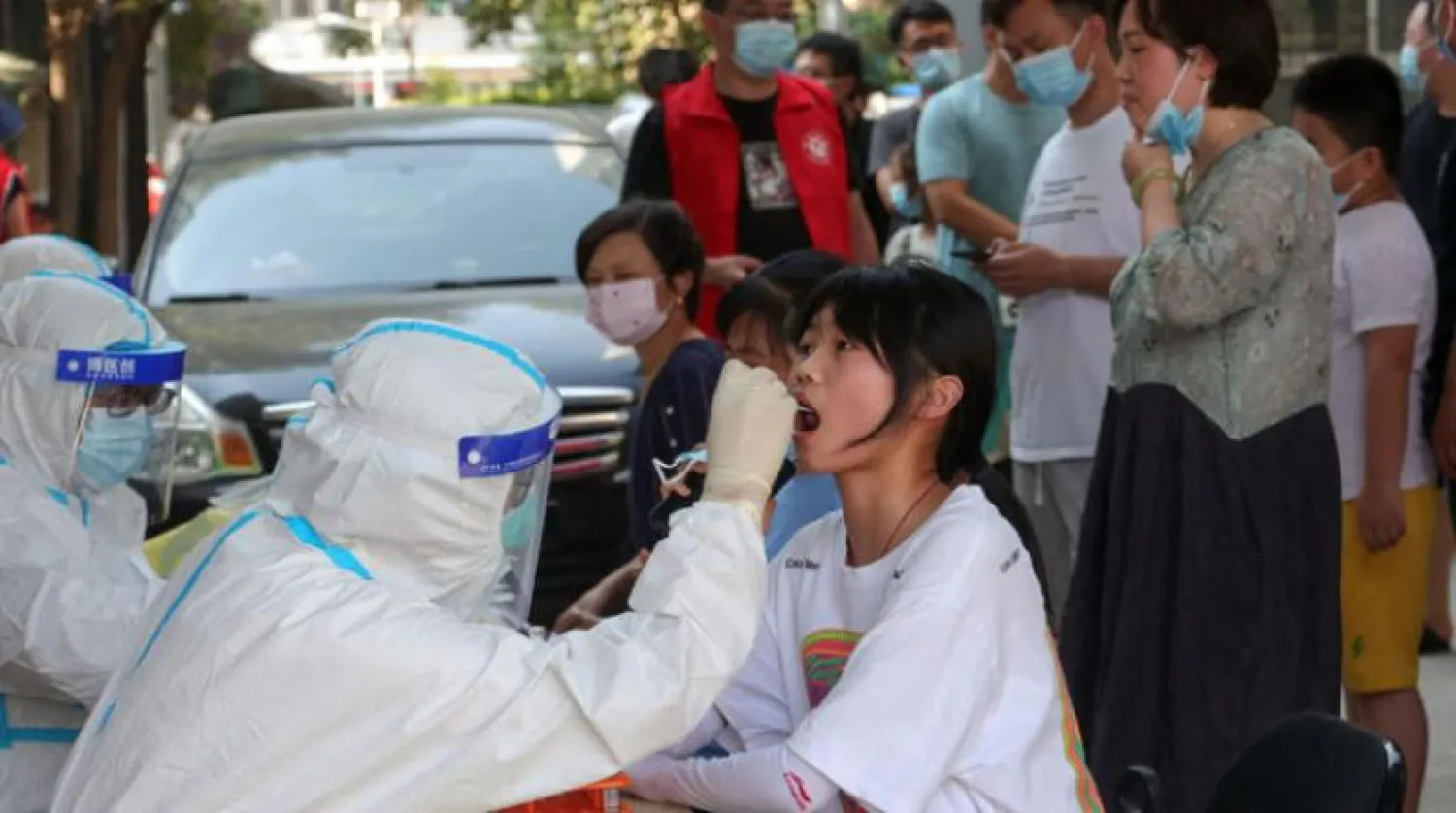 Dün Çin’in Henan eyaletinde bir kız Kovid-19 testi olurken (AFP)
