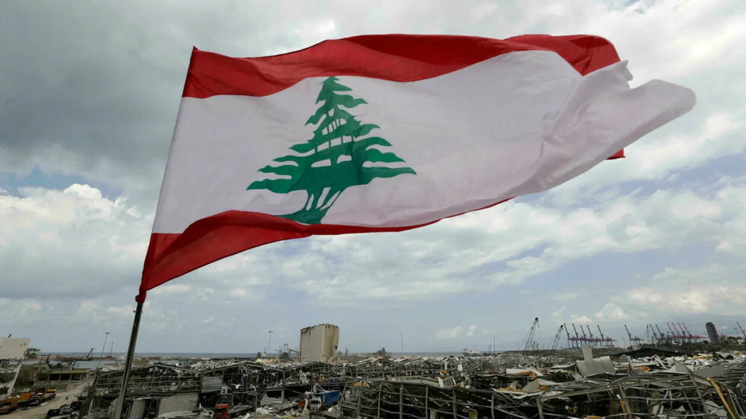 In this August 9, 2020 photo, a Lebanese flag set by citizens flies in front of the site of the deadly August 4 explosion at the Port of Beirut. (AP)