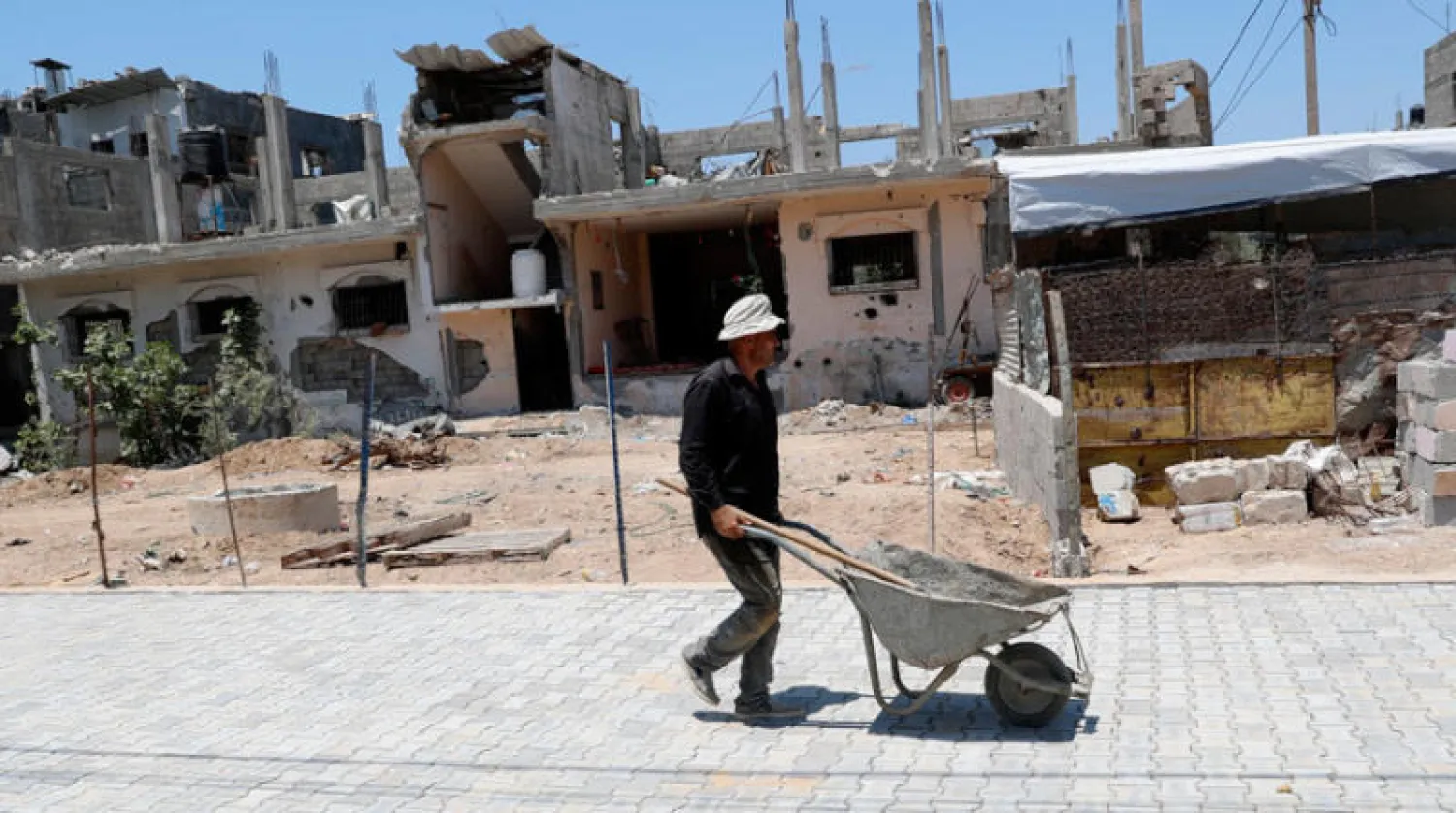 ترميم شارع في غزة تعرض لقصف إسرائيلي عنيف في مايو (أ.ب)