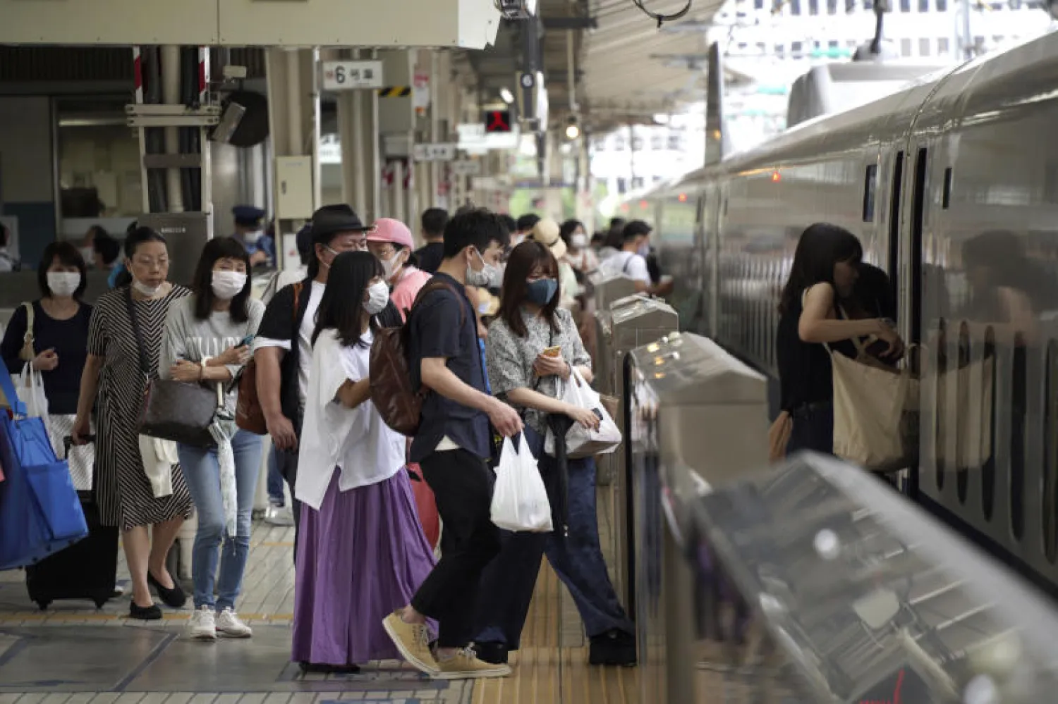 ركاب يرتدون أقنعة الوجه في محطة قطار بطوكيو(ا.ب)