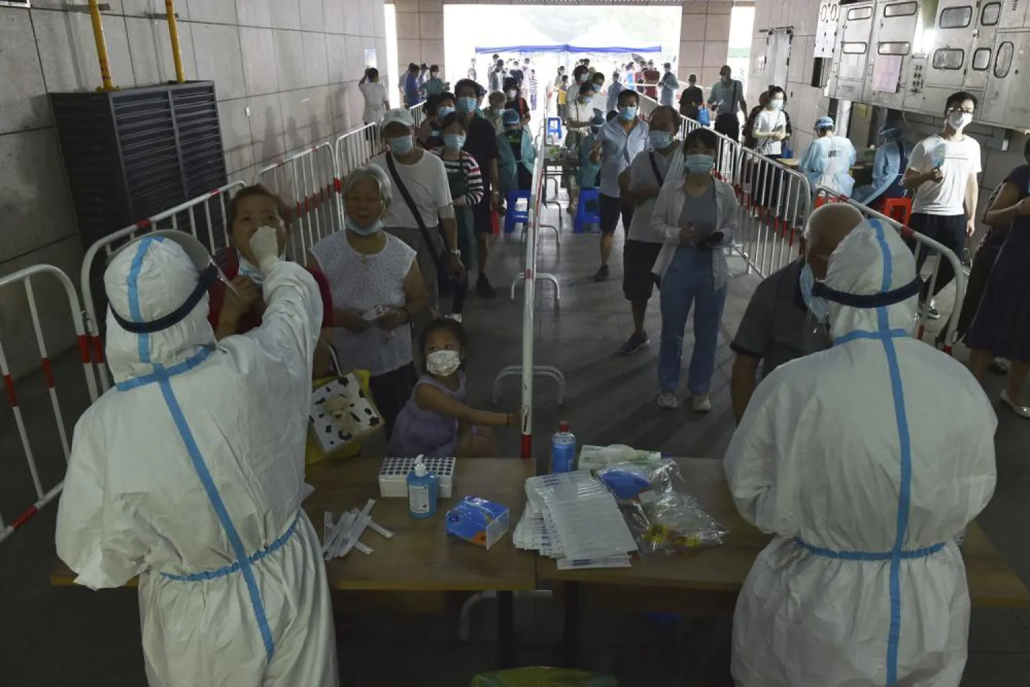 Medical workers takes throat swab samples in new round of COVID-19 testing in Nanjing city in eastern China's Jiangsu province Monday, Aug. 2, 2021. (AP)