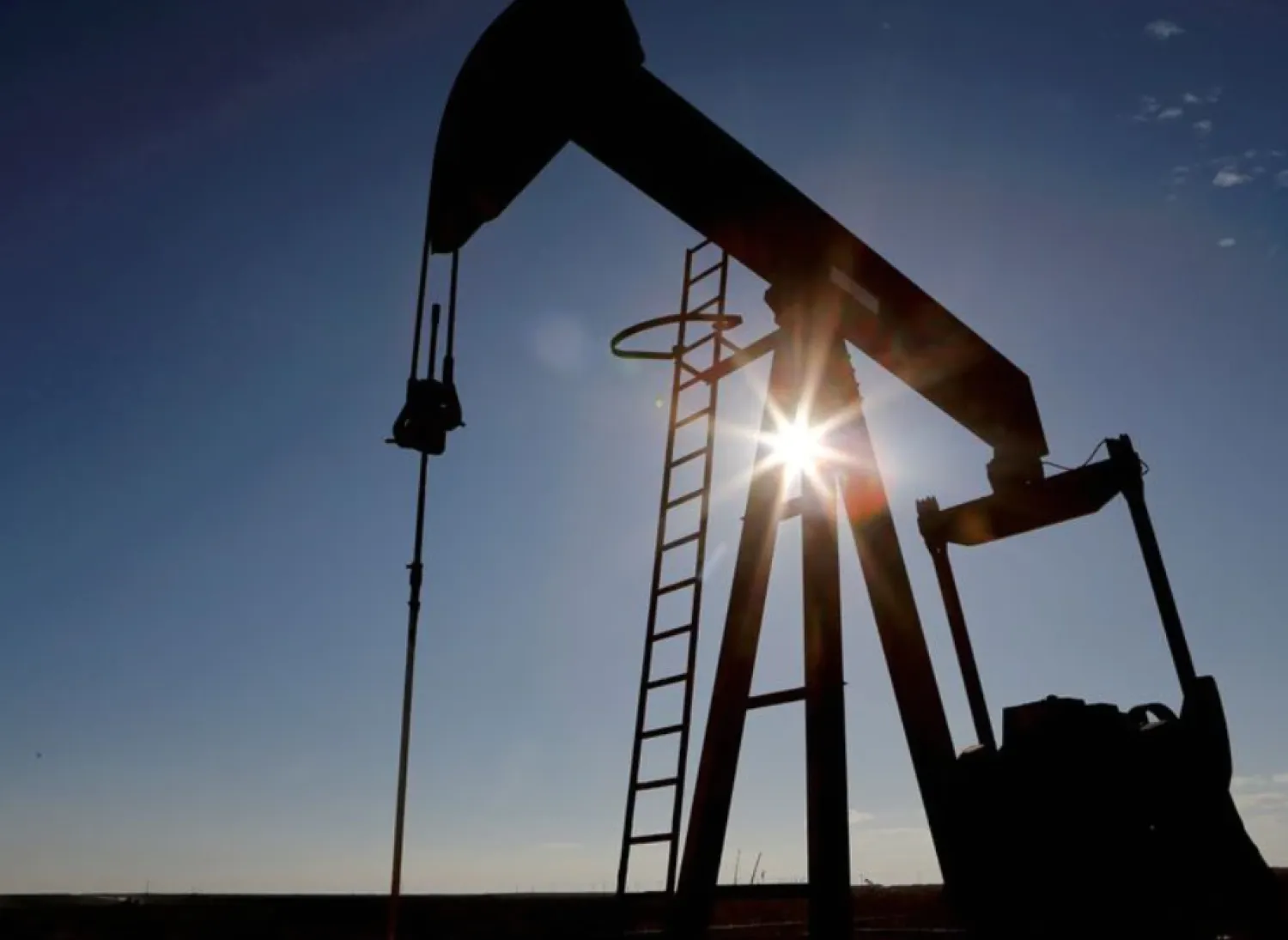 The sun is seen behind a crude oil pump jack in the Permian Basin in Loving County, Texas, US, November 22, 2019. REUTERS/Angus Mordant/File Photo