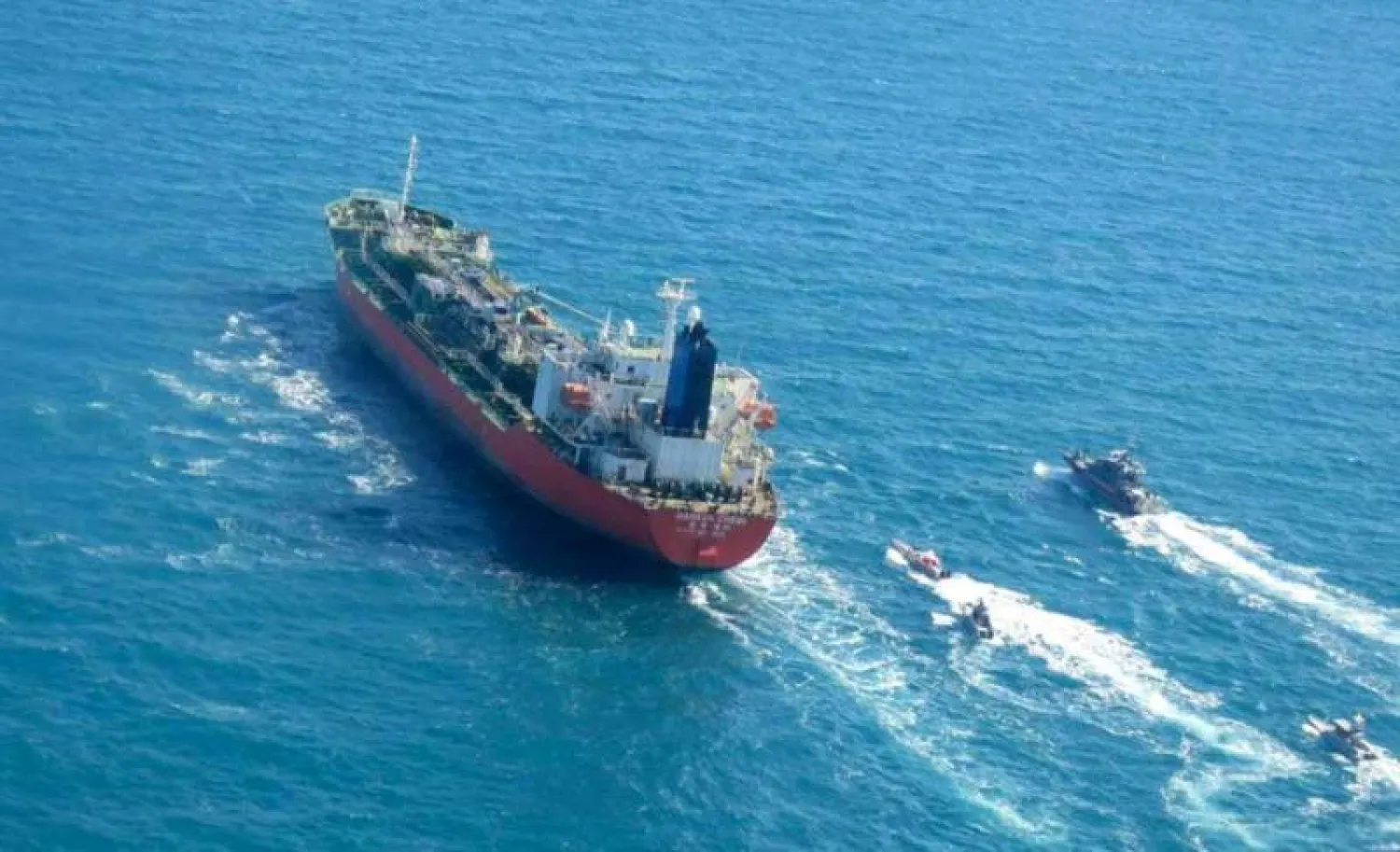 An oil tanker sailing Arab Gulf waters escorted by boats belonging to the Iranian Revolutionary Guards. (AP)