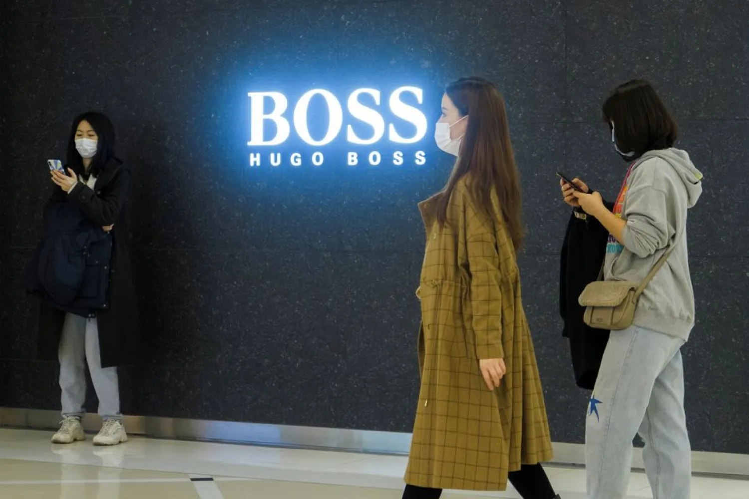 People walk past a store of German fashion house Hugo Boss in Beijing, China, March 27, 2021. (Reuters)