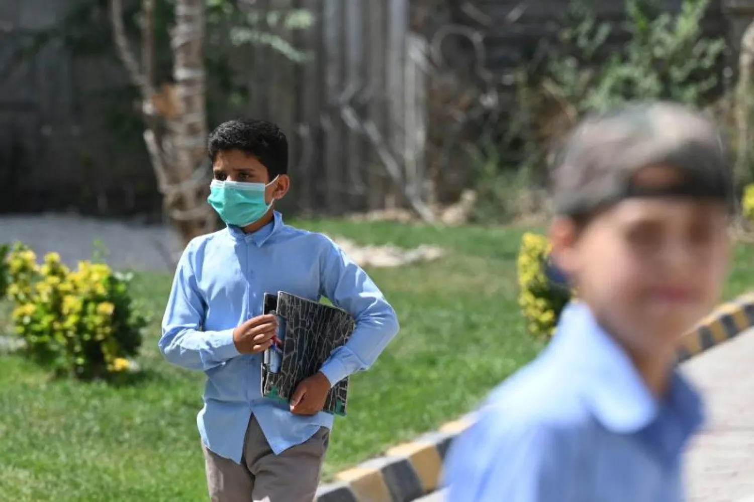 طفل أفغاني في المدرسة يسير على ممر مشاة في كابل (أ.ف.ب)