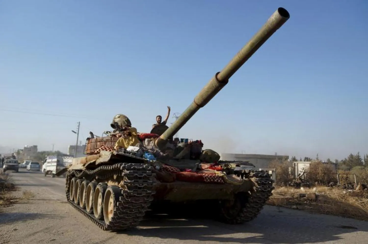  A member of the Free Syrian Army gestures as he stands on a tank after they captured the military Brigade 52 base in Daraa, Syria June 9, 2015. REUTERS/Alaa Al-Faqir