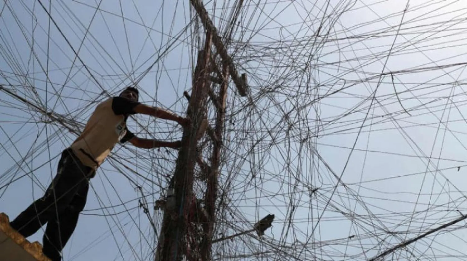 An Iraqi power grid worker amid electric cables in Sadr City, east of Baghdad (AFP)
