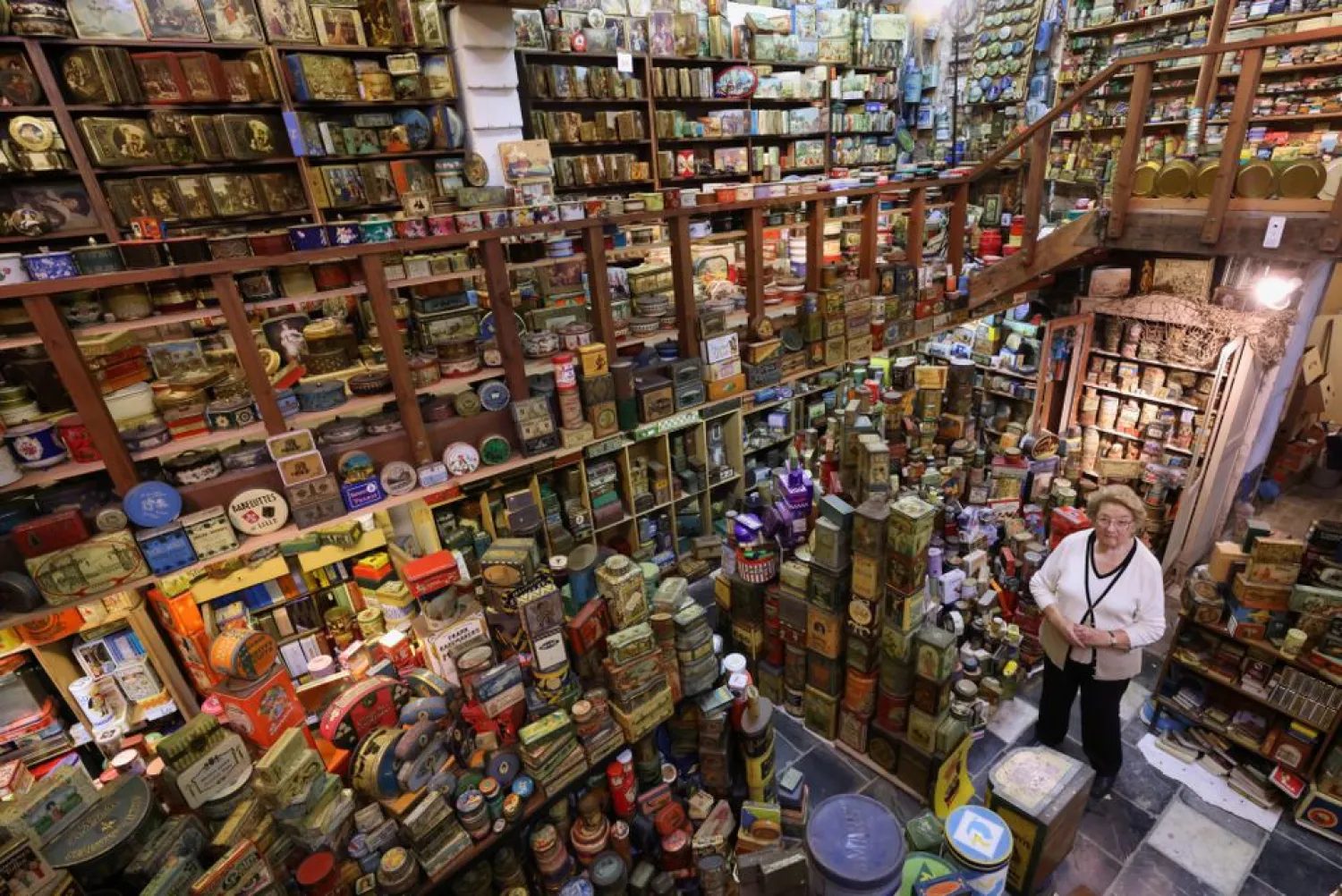 Yvette Dardenne, 83, from Belgium stands among thousands of vintage lithographed tin boxes at her house in Grand-Hallet, Belgium August 5, 2021. Picture taken August 5, 2021. (Reuters)