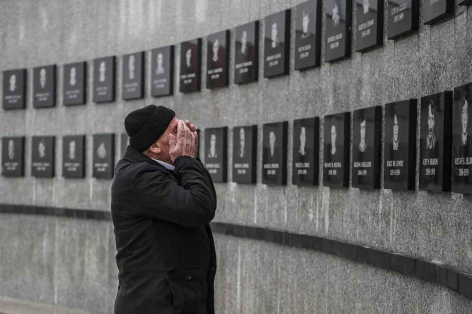 Sırp katliamının kurbanları adına yapılan anıtın önünde dua eden Kosovalı bir Arnavut. (AFP)