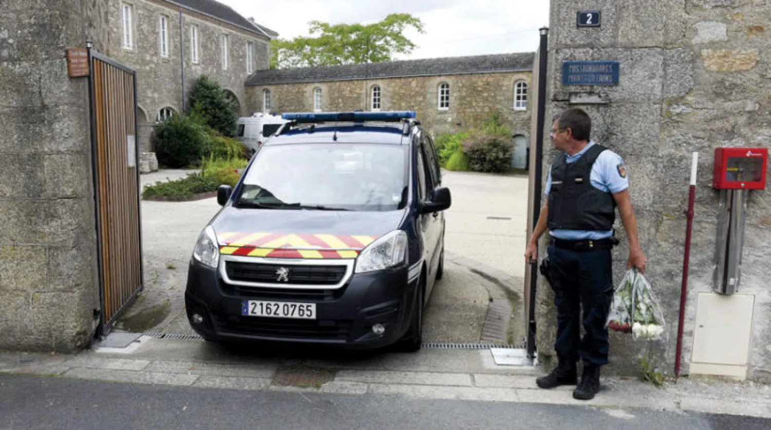 سيارة شرطة تغادر مدخل كنيسة بلدة سان لوران سور سيفر الواقعة غرب فرنسا حيث قُتل الكاهن الكاثوليكي أوليفيه مير أول من أمس (أ.ف.ب)