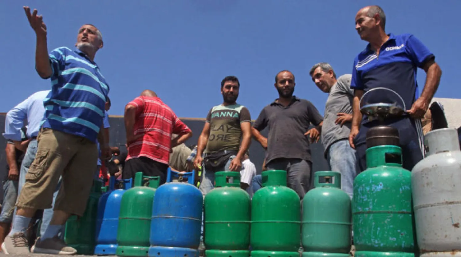 لبنانيون ينتظرون أمس لتعبئة قوارير الغاز المنزلي (أ.ف.ب)