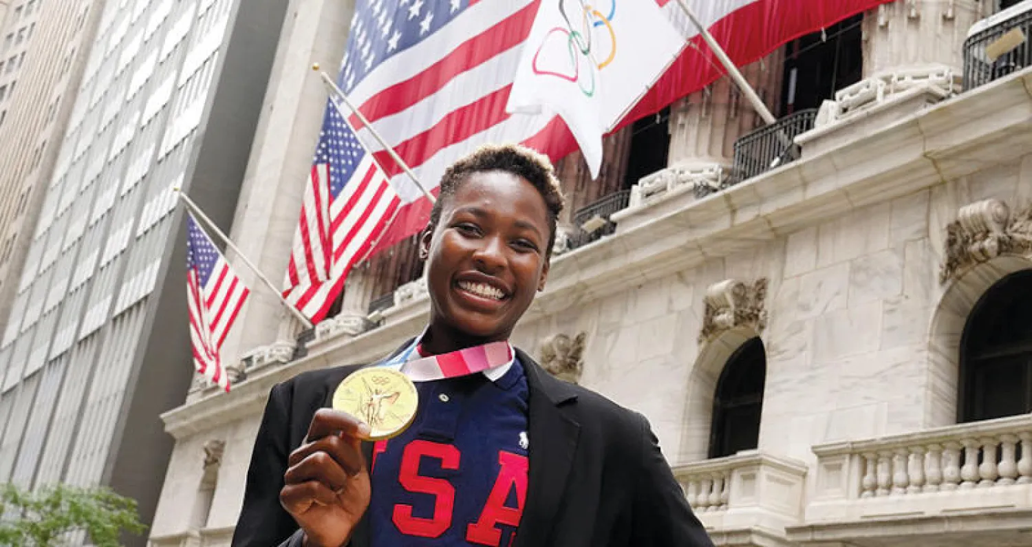 بطلة مسابقات الووتر بولو الأميركية آشلي جونسون تحتفل في وول ستريت (أ.ب)