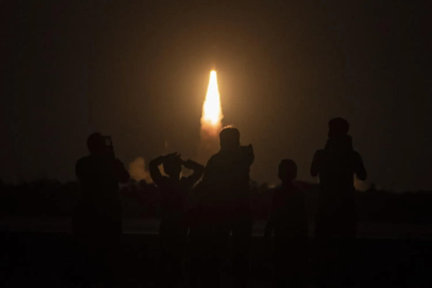 أشخاص يشاهدون محاولة إطلاق الصاروخ من مركز ساتيش داوان الفضائي في سريهاريكوتا بالهند (إ.ب.أ)